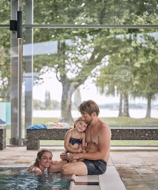 Familie am Beckenrand im Hallenbad Auqastaad in Immenstaad am Bodensee
