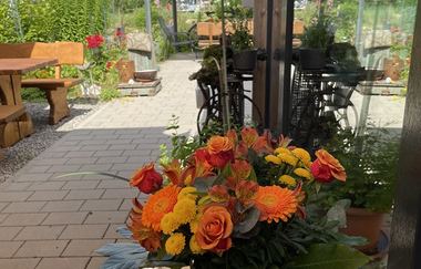 Ansicht des Biergartens mit Blumenstrauß | © Touristikgemeinschaft Hohenlohe e. V. | Wohnmobilstellplatz HEICamp