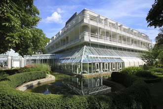 Außenansicht des Best Western Premier Parkhotels mit Glasfassade, mehreren Etagen und einem Teich mit umliegendem Grün | © Best Western Premier Parkhotel