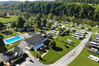 Blick auf einen Campingplatz mit einem Freibad und vielen Wohnmobilen. Im Hintergrund fließt ein Fluß (Neckar). Neckarzimmern im Odenwald | © Wohnmobilstellplatz + Campingplatz CIMBRIA