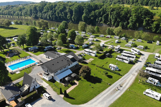 Blick auf einen Campingplatz mit einem Freibad und vielen Wohnmobilen. Im Hintergrund fließt ein Fluß (Neckar). Neckarzimmern im Odenwald | © Wohnmobilstellplatz + Campingplatz CIMBRIA