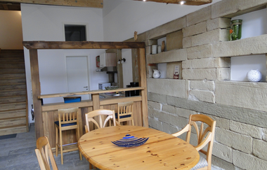 Im Esszimmer steht ein Holztisch mit Stühlen vor einer rustikalen weiß gestrichenen Mauer | © Touristikgemeinschaft Hohenlohe e. V. | Familie Carle