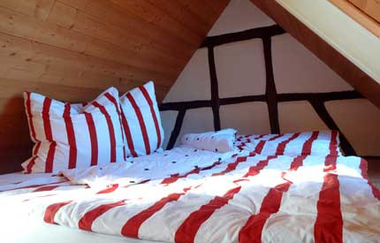Das zweite Schlafzimmer mit Doppelbett unter der Dachschräge | © Touristikgemeinschaft Hohenlohe e. V. | Klaus Schirmer