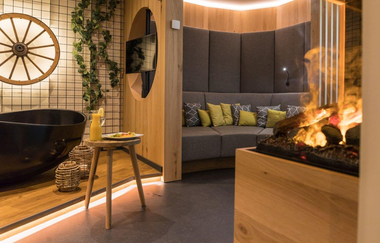 Im Spa steht eine schwarze Badewanne und ein gemütlicher Loungebereich | © Touristikgemeinschaft Hohenlohe e. V. | Thomas Rathay