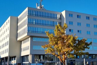 Außenansicht des Exo Square Hotels Heidelberg-Schwetzingen, mehrstöckiges modernes Gebäude vor blauem Himmel.