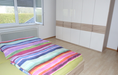 Im Schlafzimmer steht ein Doppelbett und ein Schrank. | © Touristikgemeinschaft Hohenlohe e. V. | Familie Hübel