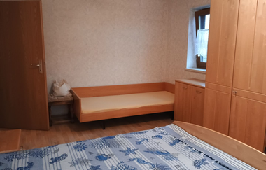 Im Schlafzimmer steht ein Doppelbett, ein Einzelbett und ein Schrank | © Touristikgemeinschaft Hohenlohe e. V.