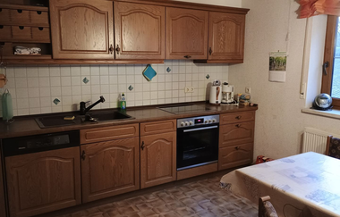 In der Küche gibt es eine Küchenzeile aus Holz und einen Esstisch | © Touristikgemeinschaft Hohenlohe e. V.