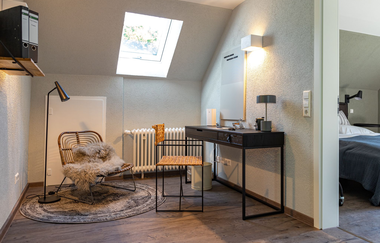 Modern eingerichtetes Zimmer mit Schreibtisch und gemütlichem Sessel im Ferienhaus Naturton | © Hohenlohe Schwäbisch Hall