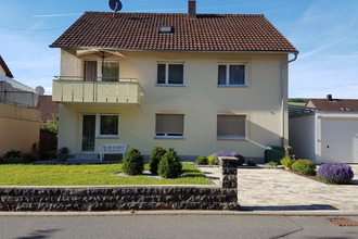 Zweistöckiges gelbes Einfamilienhaus mit Balkon, Garten, gepflasterter Einfahrt und Garage | © Beate Büchold