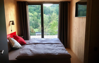 Im Schlafzimmer steht ein Doppelbett und ein TV-Gerät hängt gegenüber | © Touristikgemeinschaft Hohenlohe e. V.| Katharina Schmieg