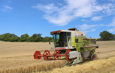ein Mähdrescher bei der Bewirtung des Feldes | © S. Carle | Ferienhof Carle