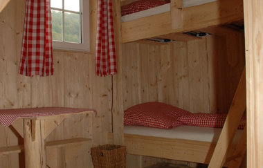 In den Radlerkojen steht ein Doppelbett und eine Sitzmöglichkeit | © Touristikgemeinschaft Hohenlohe e. V.  | Ferienhof Marina