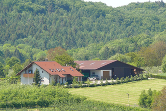 Der Ferienhof mit Haus und Scheune liegt inmitten der grünen Landschaft | © Touristikgemeinschaft Hohenlohe e. V.
