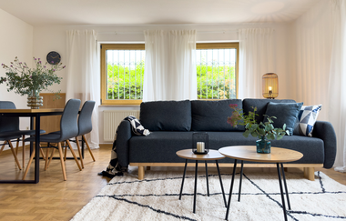 Wohnzimmer bestehend aus einer großen schwarzen Couch mit Couchtischchen und einem Esstisch mit mind. 3 Stühlen | © Neckar-Zaber-Tourismus e.V.