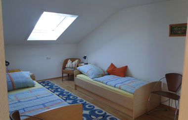 Zwei Einzelbetten mit jeweils einem Nachttischschrank mit Lampe und mehrere Stühle | © Neckar-Zaber-Tourismus e.V.