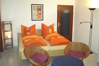 Im Wohnraum steht ein Doppelbett un zwei Stühle | © Touristikgemeinschaft Hohenlohe e. V. | Ferienwohnung Roll