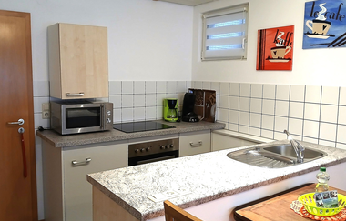 Blick in die Küche der Ferienwohnung Hipp in Brackenheim mit Ofen, Herdplatten, Mikrowelle und Kaffeemaschine | © Neckar-Zaber-Tourismus e. V.