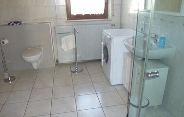 Blick in das Bad der Ferienwohnung mit Dusche, Toilette, Waschbecken und Waschmaschine | © E. Hügler