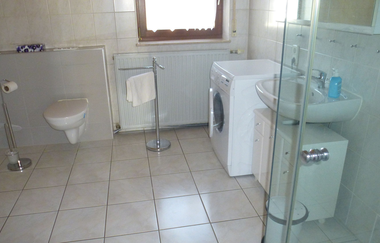 Blick in das Bad der Ferienwohnung mit Dusche, Toilette, Waschbecken und Waschmaschine | © E. Hügler