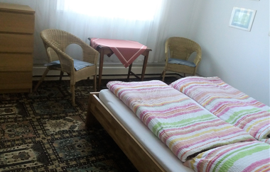 Im Schlafzimmer steht ein Doppelbett und ein Tisch mit zwei Stühlen | © Touristikgemeinschaft Hohenlohe e. V. | Ferienwohnung Jagstblick