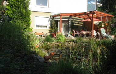 Im Garten erwartet dich ein überdachter Sitzplatz mit Tisch und Stühlen | © Touristikgemeinschaft Hohenlohe e. V. | Ferienwohnung Jagstblick