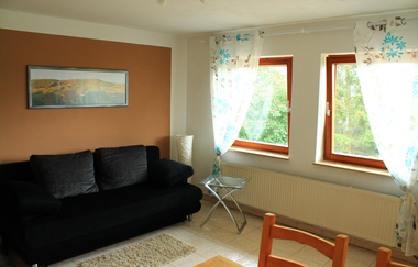 Das Wohnzimmer mit Couch und Essgelegenheit | © Touristikgemeinschaft Hohenlohe e. V. | Ferienwohnung Kraft