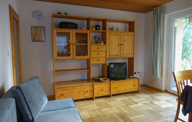 Wohnraum mit Couch, großem Holzschrank mit Fernseher und Tisch | © Neckar-Zaber-Tourismus e.V.