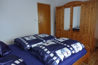 Schlafzimmer: Bett mit blauer Bettwäsche und ein großer Holzschrank mit Spiegel | © Neckar-Zaber-Tourismus e.V.