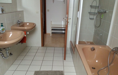 Badezimmer mit Badewanne und zwei Waschbecken und Dusche