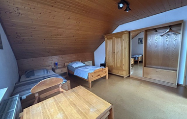 Blick in ein Schlafzimmer der Ferienwohnung mit zwei Betten, einem kleinen Tisch und Schränken | © Neckar-Zaber-Tourismus e.V.