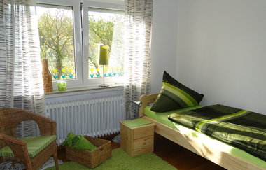 Schlafzimmer mit Einzelbett und Nachttisch und einem Stuhl | © Neckar-Zaber-Tourismus e.V.