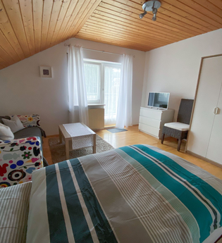 Zimmer mit einem Bett, einer Couch + Tisch und einem großen weißen Kleiderschrank | © Neckar-Zaber-Tourismus e.V.