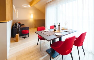 Essecke bestehend aus einem Holztisch und vier roten Stühlen, im Hintergrund eine Couch | © Neckar-Zaber-Tourismus e.V.