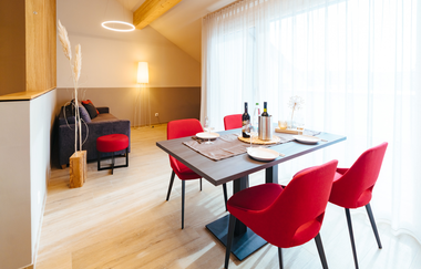 Essecke bestehend aus einem Holztisch und vier roten Stühlen, im Hintergrund eine Couch | © Neckar-Zaber-Tourismus e.V.