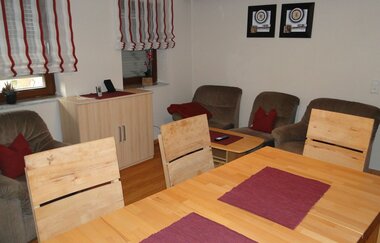 Wohn- und Esszimmer mit großem Esstisch und Stühlen. Hinten sind mehrere Couchsessel und noch ein Schrank. | © Neckar-Zaber-Tourismus e.V.