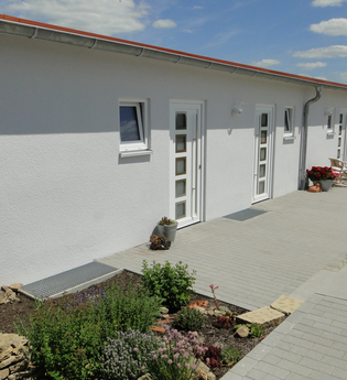 Außenansicht der Ferienwohnung; weißes recht flaches Gebäude mit mehreren Türen und rotem Dach | © Neckar-Zaber-Tourismus e.V.