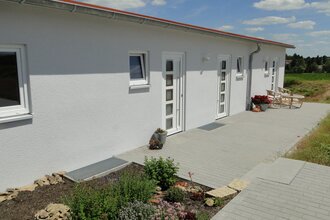 Außenansicht der Ferienwohnung; weißes recht flaches Gebäude mit mehreren Türen und rotem Dach | © Neckar-Zaber-Tourismus e.V.