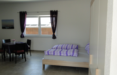 Wohn- und Schlafraum mit Doppelbett und einem quadratischen Tisch mit mind. 3 Stühlen | © Neckar-Zaber-Tourismus e.V.