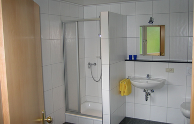 Badezimmer mit Dusche, Toilette und Waschbecken