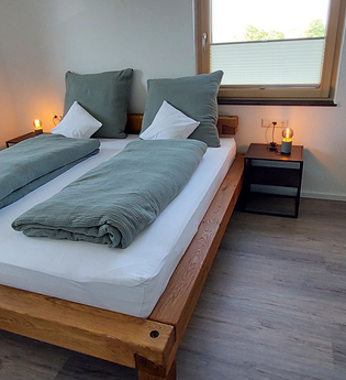 Doppelbett mit zwei Nachttischschränkchen und einem grauen kleinen Schrank an der Seite | © Neckar-Zaber-Tourismus e.V.