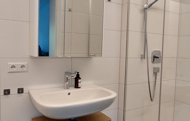 Badezimmer mit Waschbecken und Spiegelschrank und rechts eine große Dusche | © Neckar-Zaber-Tourismus e.V.