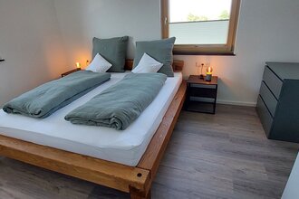 Doppelbett mit zwei Nachttischschränkchen und einem grauen kleinen Schrank an der Seite | © Neckar-Zaber-Tourismus e.V.