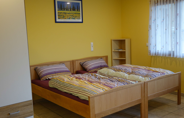 Schlafzimmer mit zwei Betten, einem kleinen Regal und Fenster | © Neckar-Zaber-Tourismus e.V.