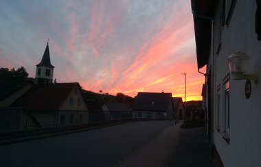 Sonnenuntergang beim Gästehaus bei Knieles mit Blick auf die Kirche | © Touristikgemeinschaft Hohenlohe e. V. | Gästehaus bei Knieles