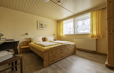 Rustikales Doppelbett und Tisch mit Stuhl | © Touristikgemeinschaft Hohenlohe e.V. | Dominik Rau