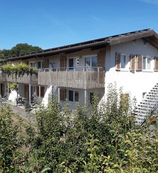 Außenansicht: weißes Gebäude und dunkles Dach