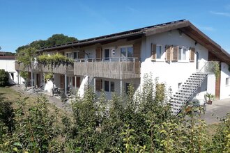 Außenansicht: weißes Gebäude und dunkles Dach
