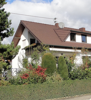 Das Gästehaus ist außen umgeben von vielen grünen Sträuchern. | © Touristikgemeinschaft Hohenlohe e. V. | Ferienwohnung / Gästehaus Heßlinger