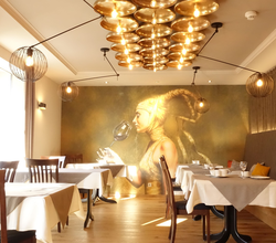 Frühstücksraum mit goldenem Bild von einer Frau im Hintergrund. Rechts gibt es eine Sitzbank mit Kissen und links stehen die Tische am Fenster. | © Neckar-Zaber-Tourismus e.V.